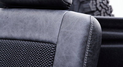 Close-up of black and gray textured upholstery with visible stitching on Classic Ford Bronco seat.