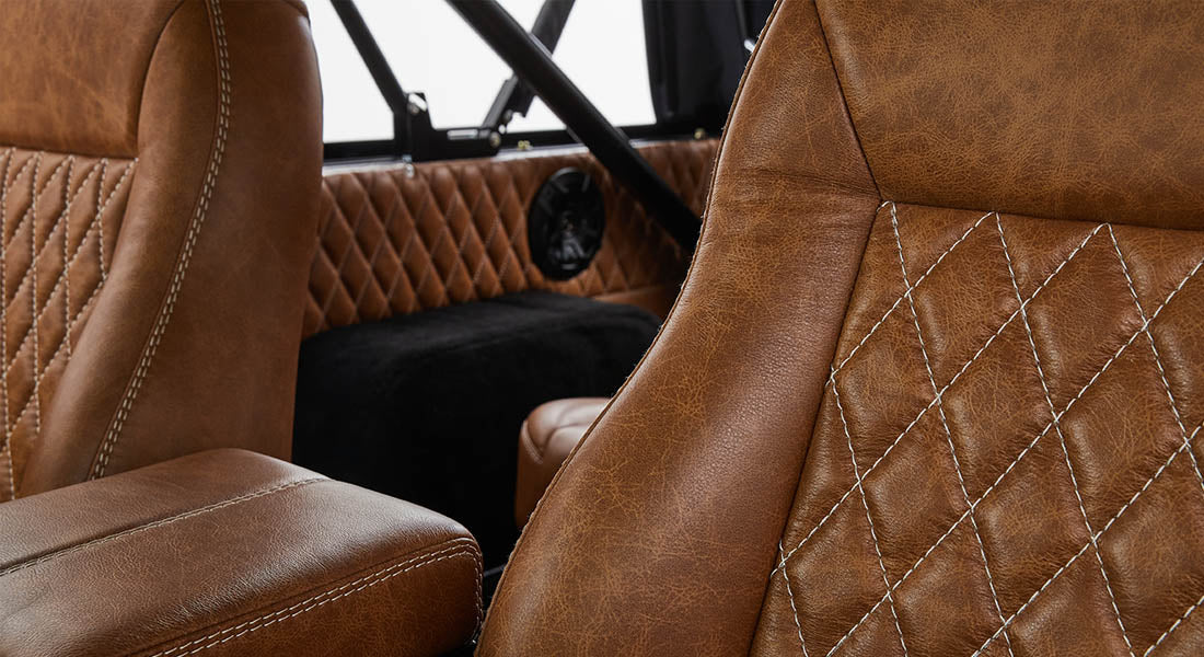 1976 Blue Classic Ford Bronco Coyote Series with black soft top and whiskey leather interior
