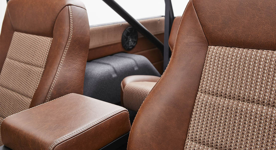 Brown and beige woven upholstery and leather seats inside Classic Ford Bronco