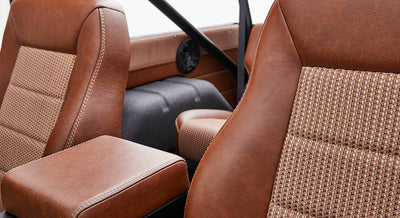 Brown and beige woven upholstery and leather seats inside Classic Ford Bronco