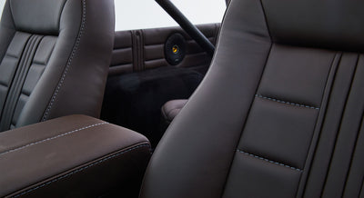 Close-up of black leather seat with detailed stitching inside Classic Ford Bronco.