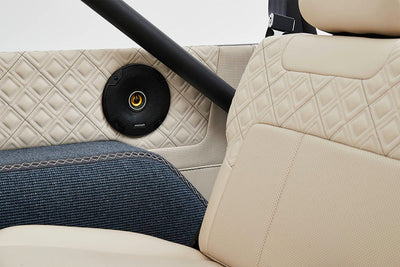 Close-up of interior upholstery featuring beige leather and a round speaker in a Classic Ford Bronco