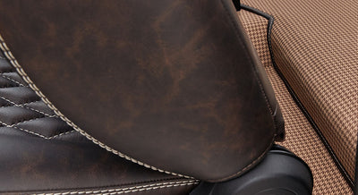 Brown leather car seat with white stitching and houndstooth fabric upholstery underneath