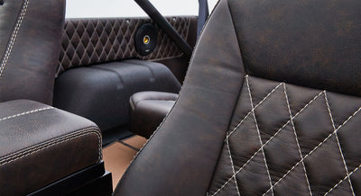 Interior close-up of diamond-stitched brown leather seats in a Classic Ford Bronco