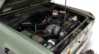 Open hood showing engine compartment of a Classic Ford Bronco with various components