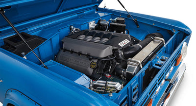 1976 Blue Classic Ford Bronco Coyote Series with black soft top and whiskey leather interior