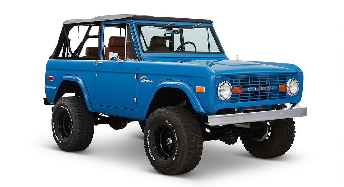 1976 Blue Classic Ford Bronco Coyote Series with black soft top and whiskey leather interior