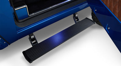 Black AMP Research power step running board extended below a vehicle door