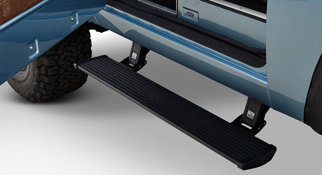 Black powerstep running board attached under a light blue Classic Ford Bronco door