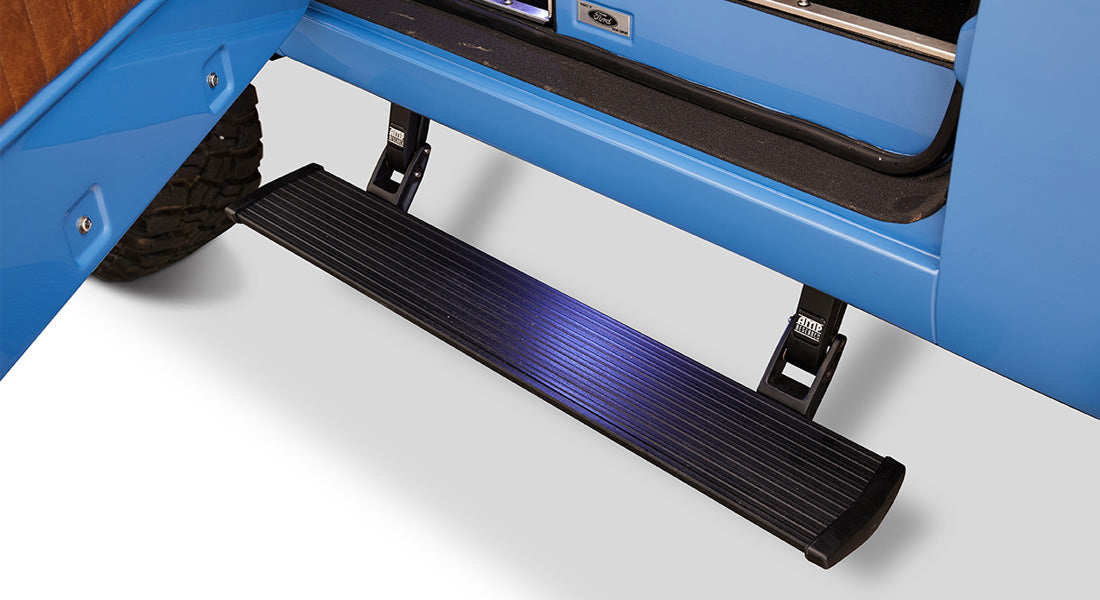 Black powerstep attached below the door of a blue Classic Ford Bronco