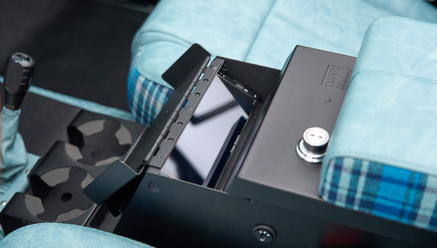 Close-up of Classic Ford Bronco center console showing lockable storage box and blue plaid upholstery
