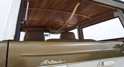 Classic Ford Bronco rear view showing back window, brown leather seats, and Artemis text on body