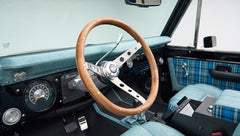 Classic Ford Bronco dashboard and steering wheel with wood finish and blue plaid seats