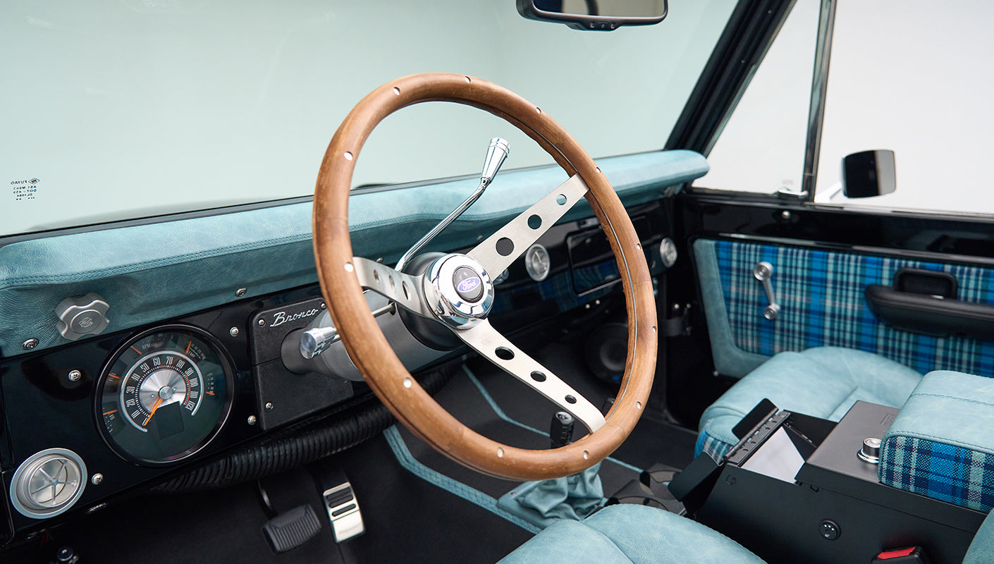 Classic Ford Bronco dashboard and steering wheel with wood finish and blue plaid seats