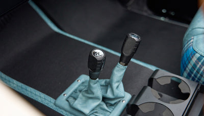 Close-up of Classic Ford Bronco dual gear shifters with blue leather boots