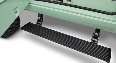 Black running board attached to light green Classic Ford Bronco beside off-road tire