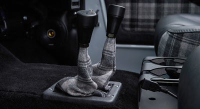 Pair of black shifter knobs with plaid fabric boots inside Classic Ford Bronco