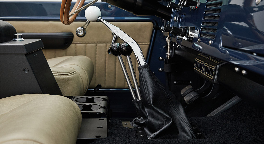 Classic Ford Bronco interior showing gear shifters and tan seats