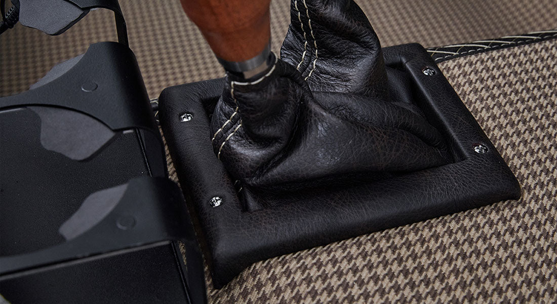 Leather shifter boot surrounding wooden gear stick on carpet inside Classic Ford Bronco