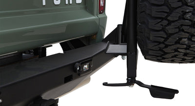 Black steel spare tire carrier mounted on green Classic Ford Bronco with large off-road tire