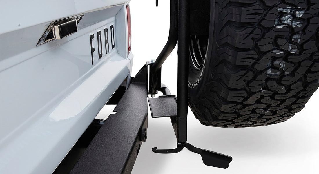 Rear view of Classic Ford Bronco tailgate with spare tire mounted and visible Ford lettering.