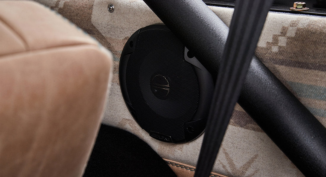 Classic Ford Bronco interior speaker mounted next to patterned fabric seat