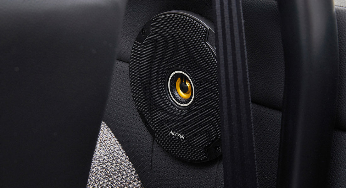 Black classic Ford Bronco speaker with yellow center mounted in rear interior