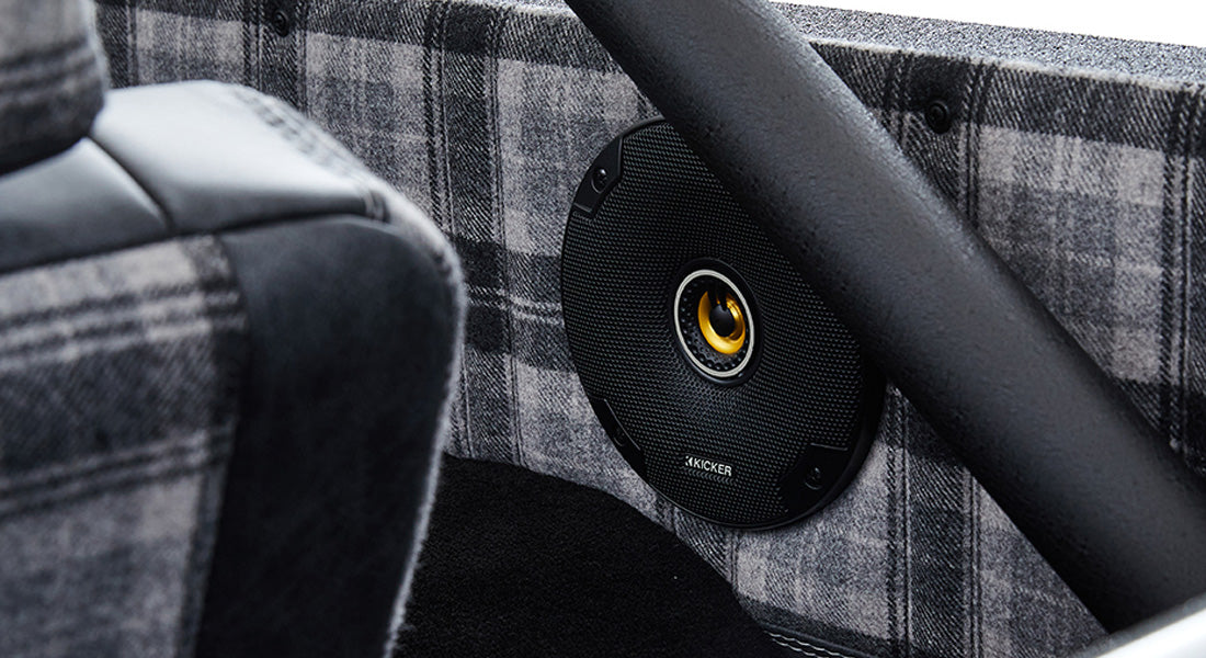 Plaid fabric interior door panel and black speaker inside a Classic Ford Bronco