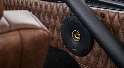 Black Kicker speaker mounted in the brown leather interior panel of Classic Ford Bronco