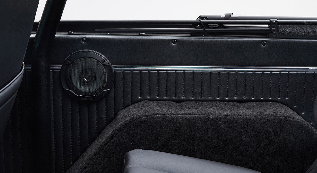 Black speaker mounted on the inside panel of a Classic Ford Bronco