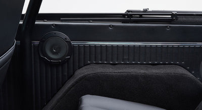 Black speaker mounted on the inside panel of a Classic Ford Bronco