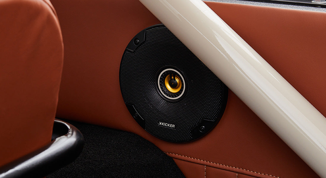 Black Kicker speaker mounted in brown leather interior panel of Classic Ford Bronco