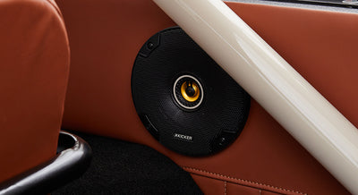 Black Kicker speaker mounted in brown leather interior panel of Classic Ford Bronco