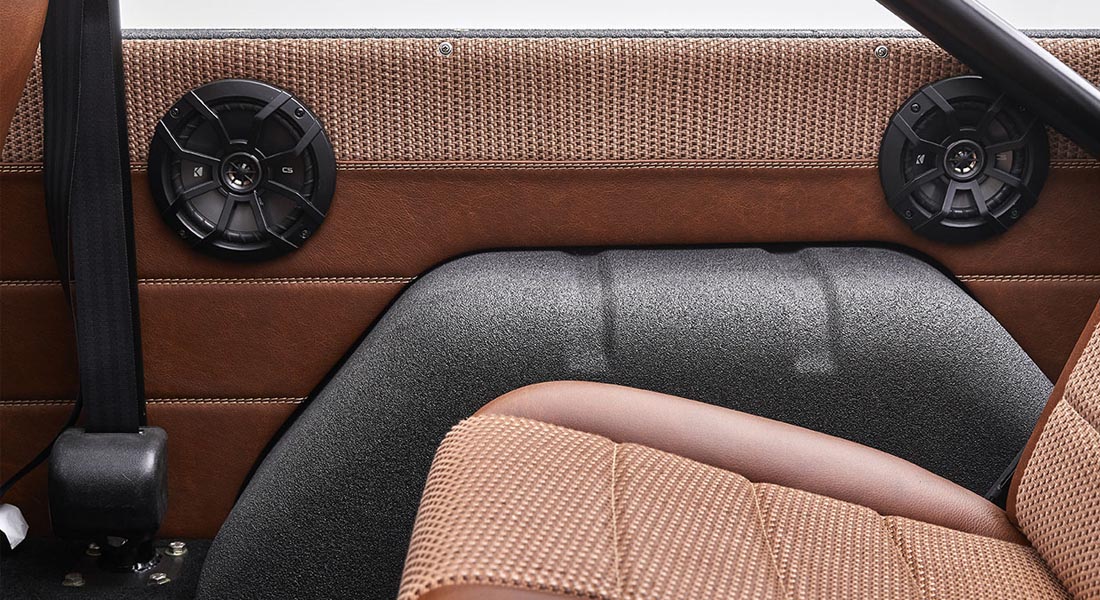 Interior side panel with black speakers and brown upholstery in Classic Ford Bronco