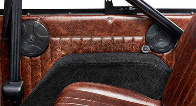 Classic Ford Bronco brown leather door panel with speaker grills and black seatbelt