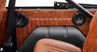 Interior side panel with black speakers and brown leather upholstery in Classic Ford Bronco