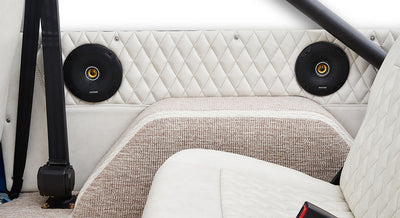 Back seat area with white diamond-stitched upholstery and speakers inside Classic Ford Bronco