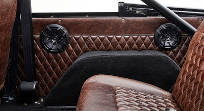 Brown quilted door panel with black speakers and a seatbelt inside Classic Ford Bronco