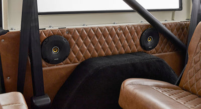 Rear interior panel with quilted brown leather and two black speakers in Classic Ford Bronco