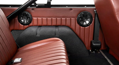 Interior side panel of Classic Ford Bronco with two black speakers and brown leather seat