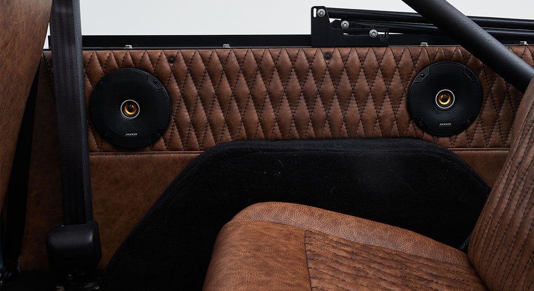 Brown quilted door panel with two black circular speakers inside a Classic Ford Bronco