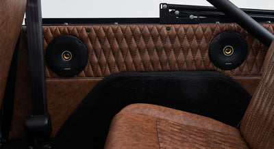 Brown quilted door panel with two black circular speakers inside a Classic Ford Bronco