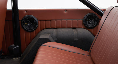 Interior side panel with two round speakers and brown upholstery in Classic Ford Bronco