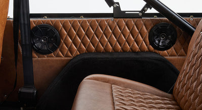 1976 Blue Classic Ford Bronco Coyote Series with black soft top and whiskey leather interior
