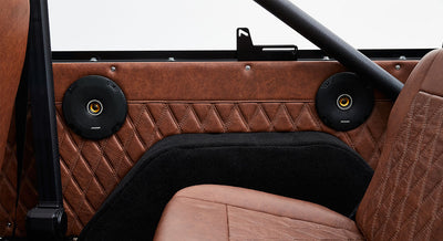 Interior door panel with speakers and brown diamond-stitched upholstery in Classic Ford Bronco