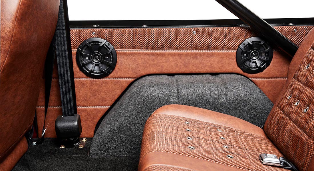 Classic Ford Bronco interior door panel with two black speakers and brown upholstery