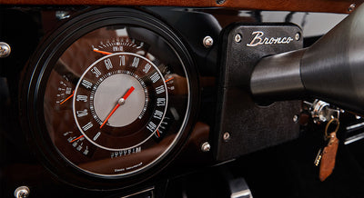 Close-up of classic Ford Bronco dashboard speedometer and tachometer with 'Bronco' badge
