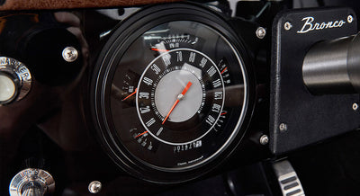 Classic Ford Bronco dashboard speedometer with Bronco logo plate nearby