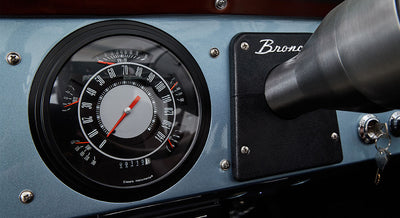 Classic Ford Bronco dashboard speedometer showing gauges and part of steering column.