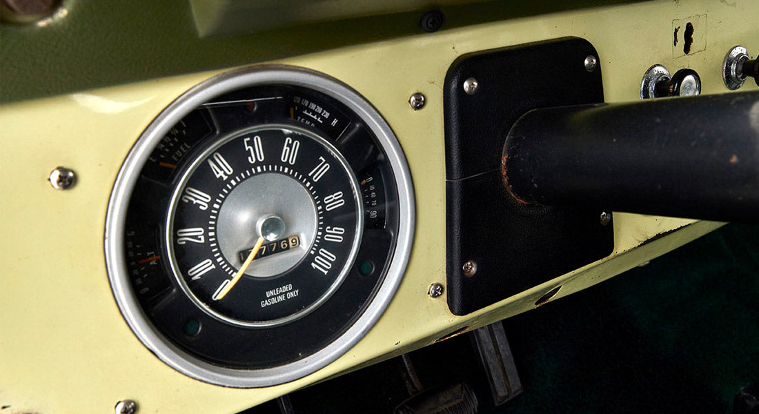 Vintage Classic Ford Bronco speedometer showing mileage on a light green dashboard